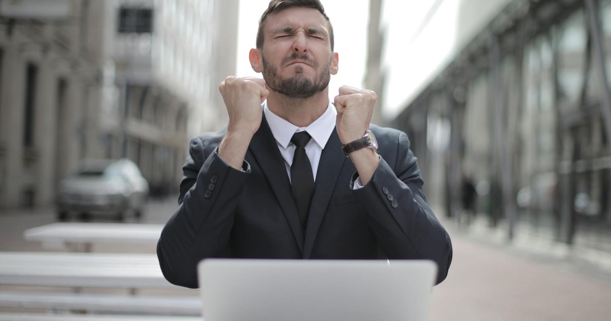 Confident businessman in Budapest celebrates success with a fist pump, reflecting a professional achievement.