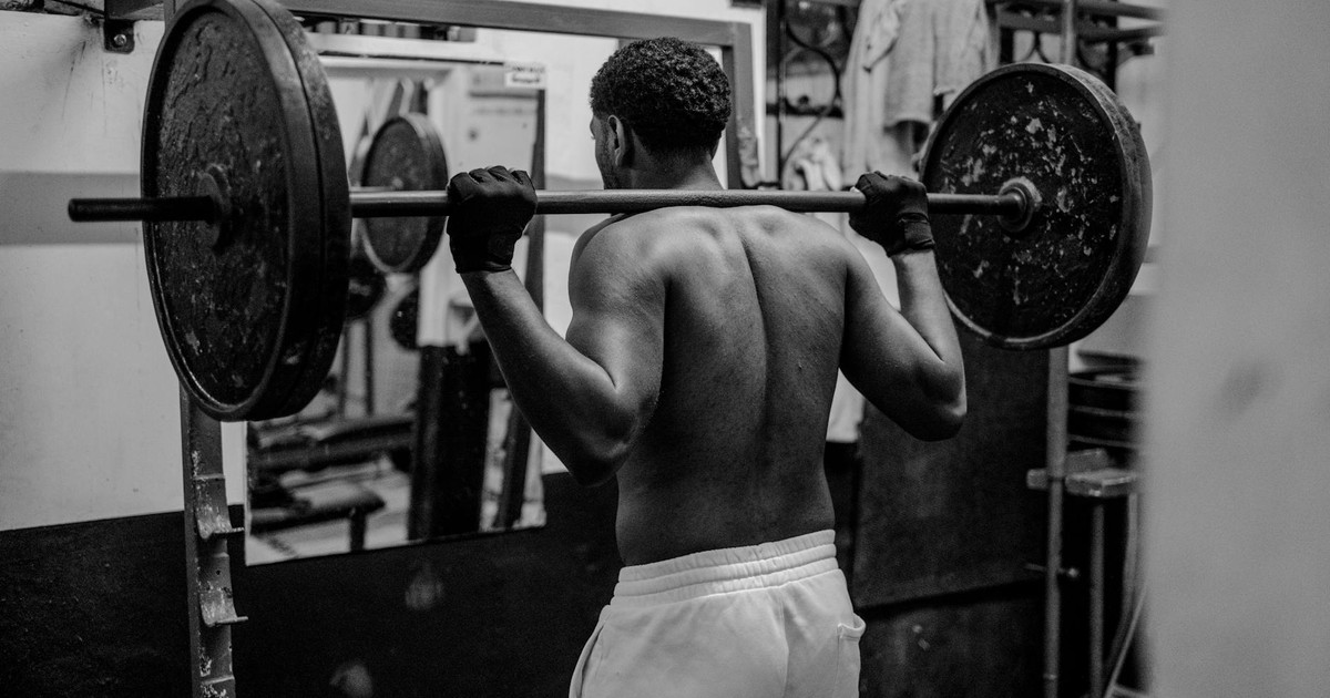 A determined man lifting weights in a gym, showcasing strength and fitness focus.