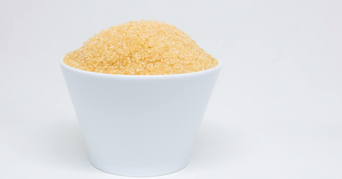 A white bowl filled with brown sugar against a clean, white background.