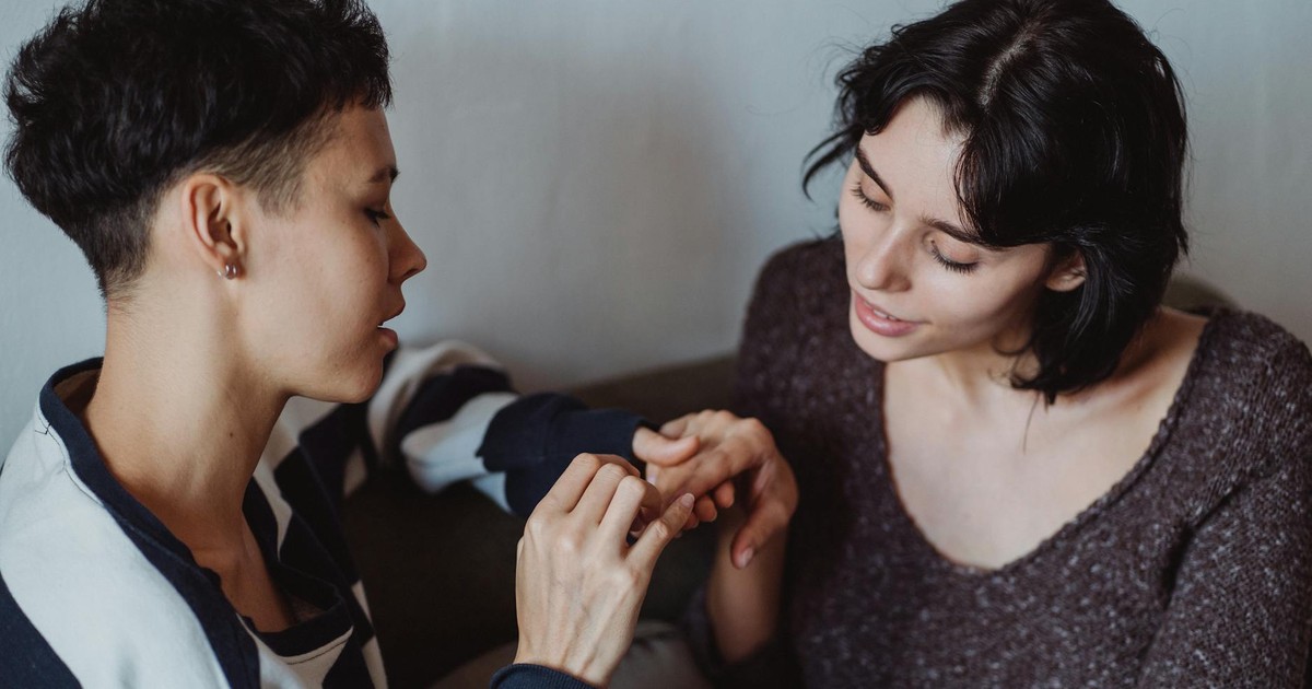 Two women sharing a tender moment while holding hands, conveying love and intimacy.