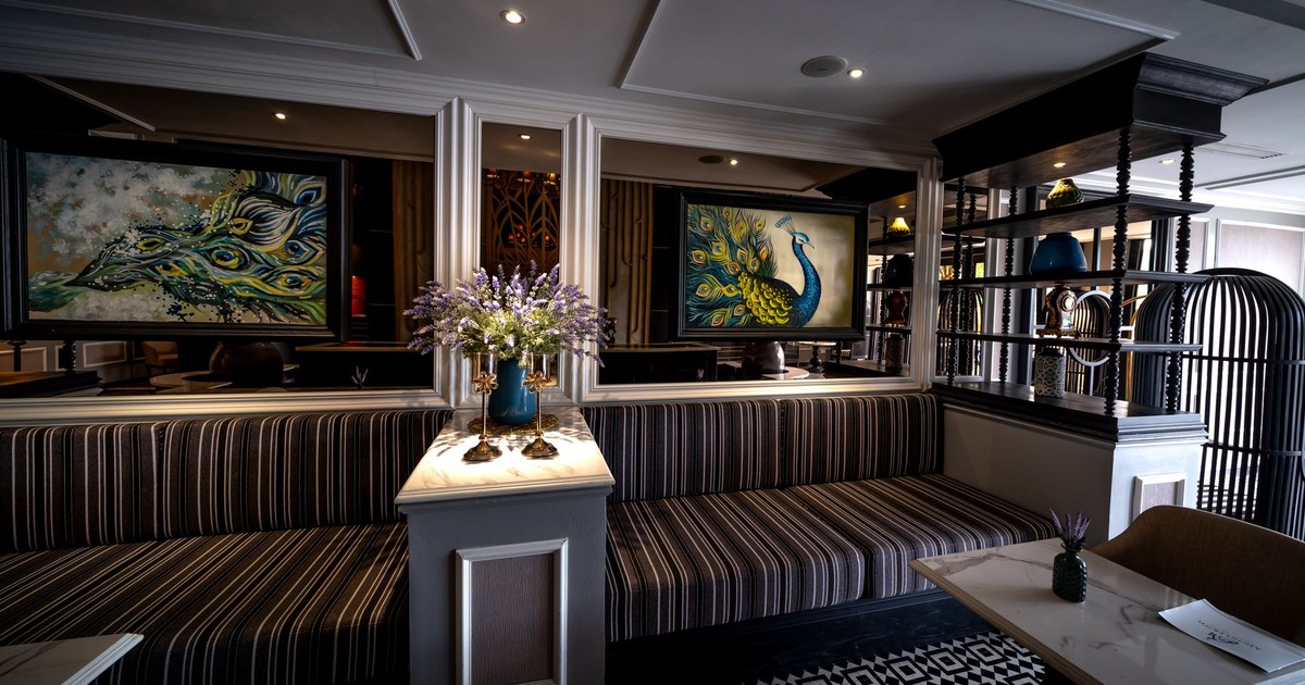 Luxurious hotel lobby featuring peacock paintings and ornate decor for a stylish ambiance.