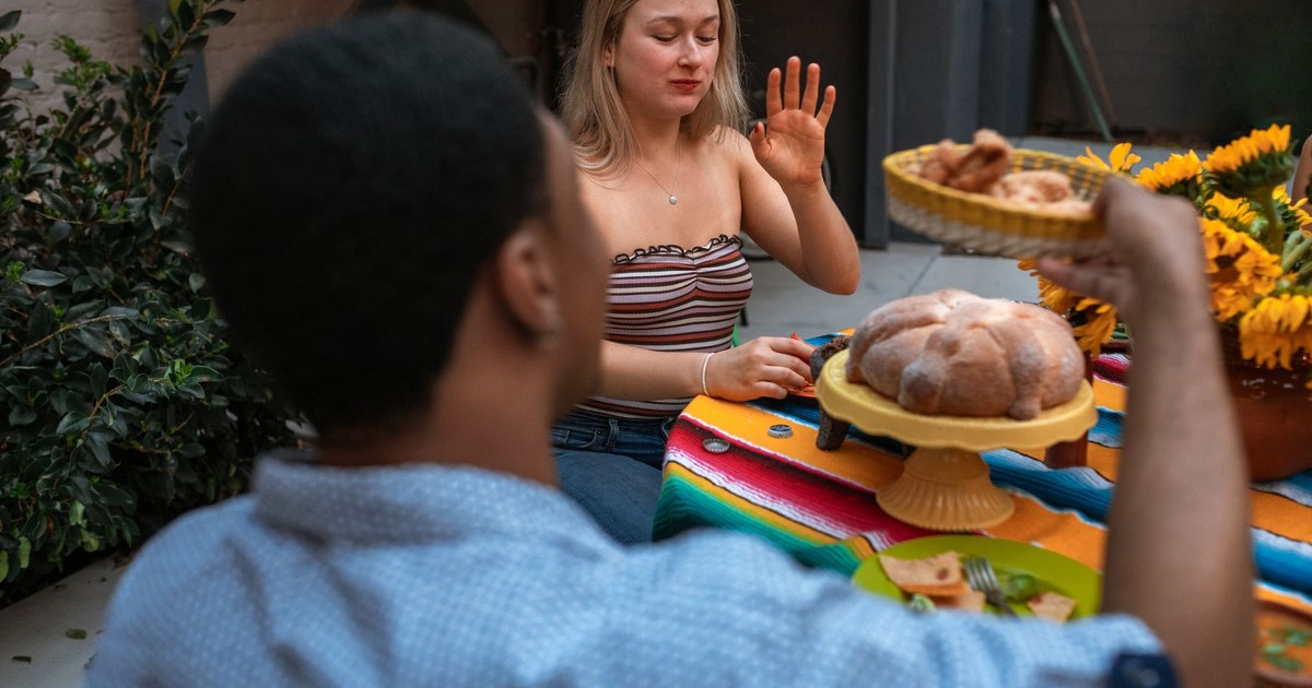 Two young friends enjoying a relaxed meal outdoors, sharing food and conversation.