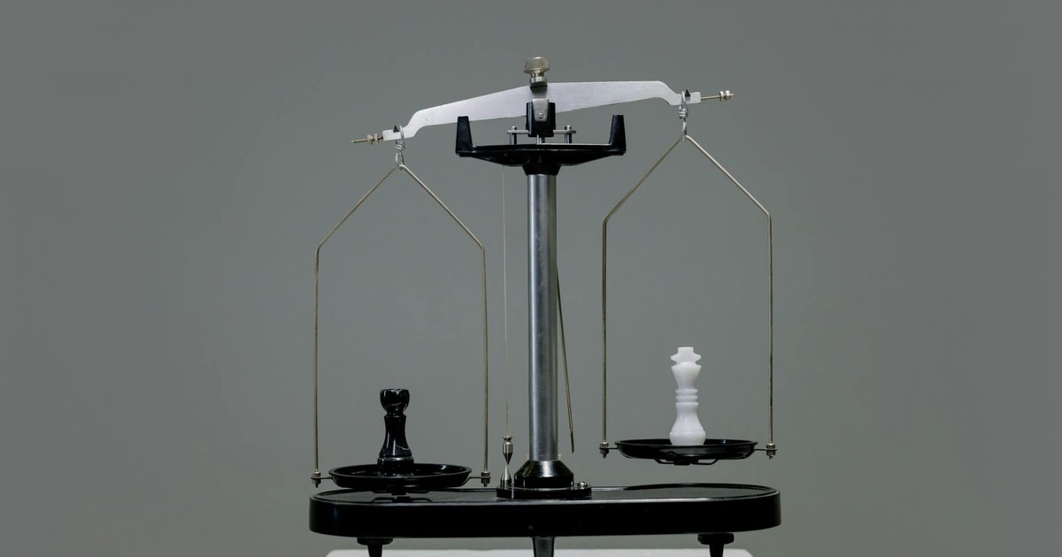 Chess pieces balanced on a scale depicting equality or strategy in decision making.