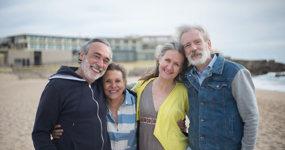 A cheerful group of mature friends enjoying a day at the beach in Portugal, showcasing togetherness.
