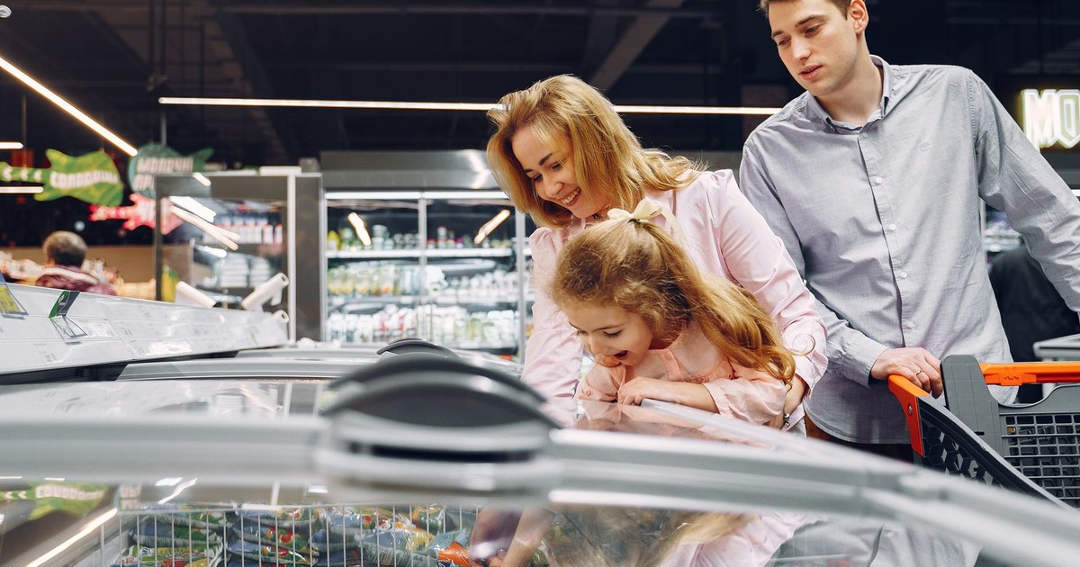 A family enjoying time together while shopping in a supermarket aisle.