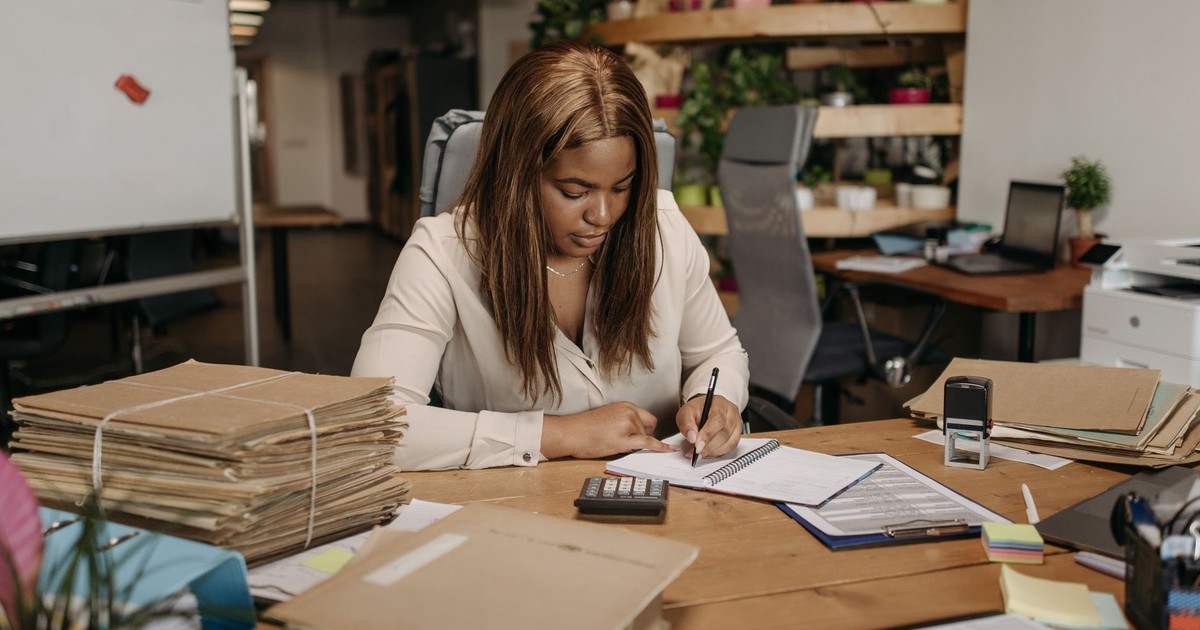 Businesswoman focused on paperwork in an organized office setting.