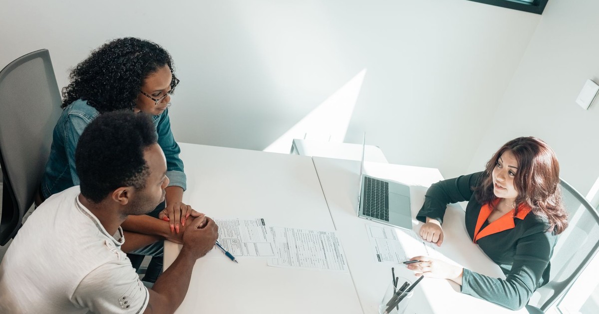 Diverse group discussing business documents in a bright, modern office setting.
