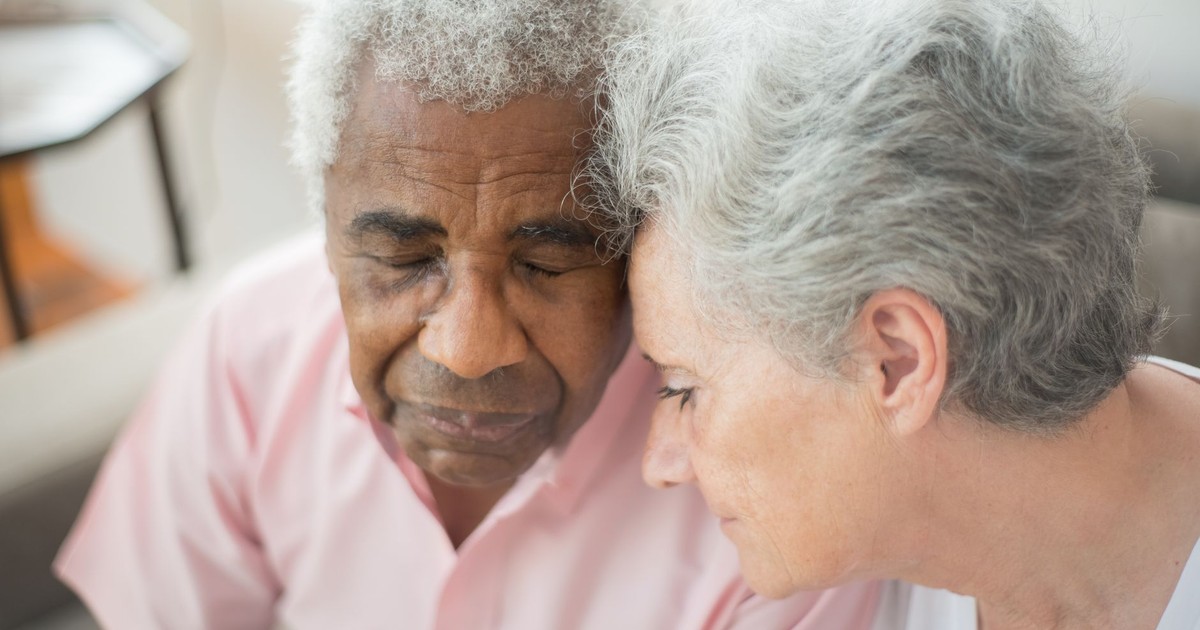 A close-up of a senior couple sharing a tender and emotional moment together.