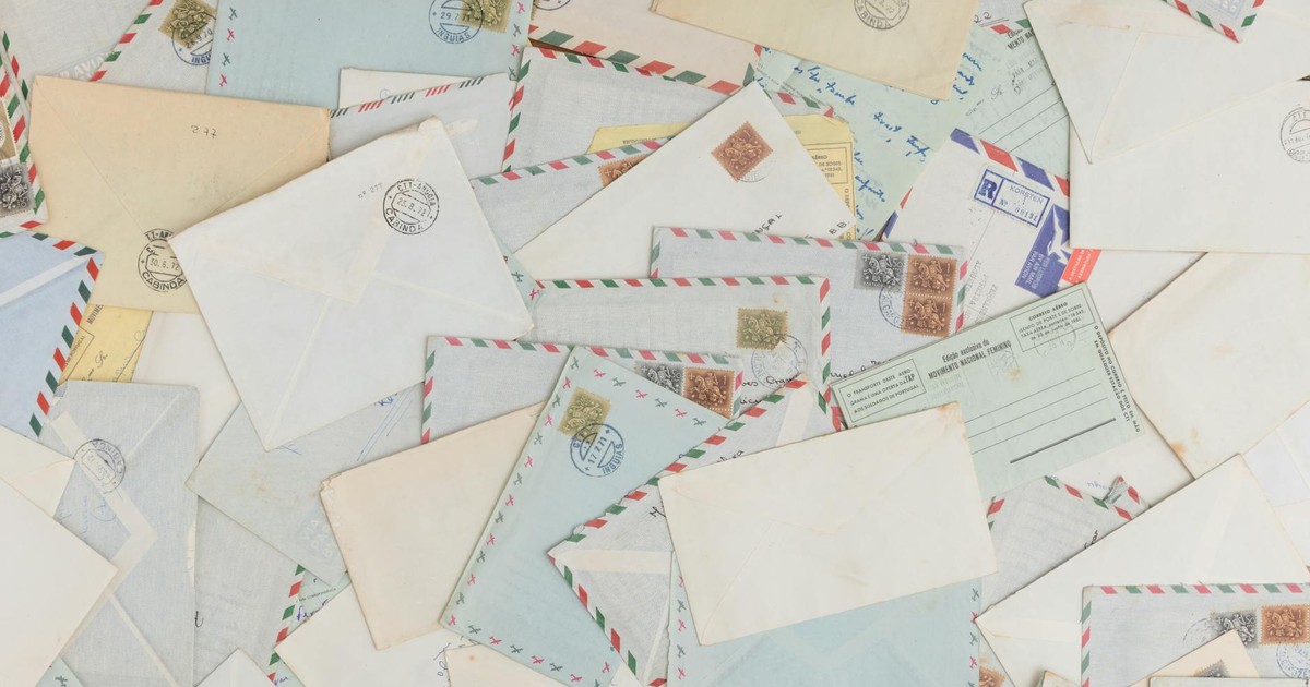 A collection of vintage airmail envelopes and postcards scattered with stamps.