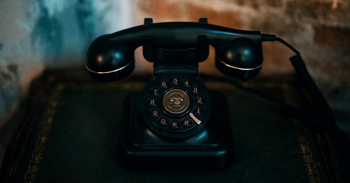 Classic black rotary telephone on a vintage table, evoking nostalgia.