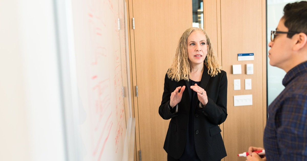 Two professionals engaged in a business discussion in a well-lit modern office space.