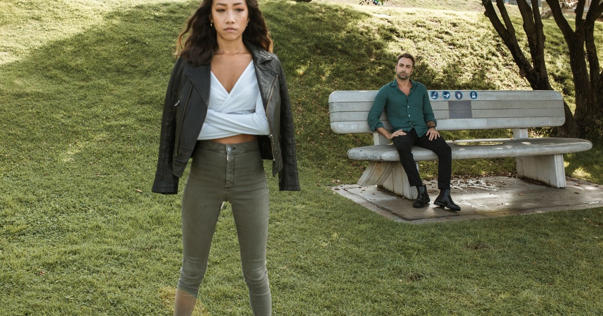 An upset couple having a disagreement while sitting on a bench in a park.