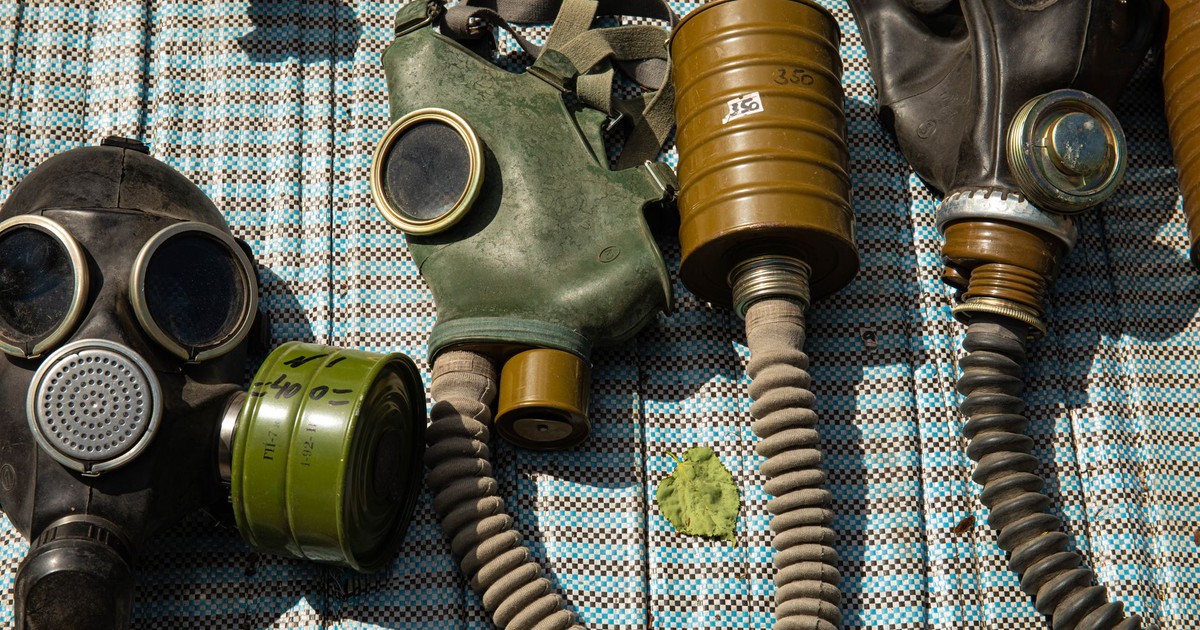 Collection of vintage gas masks placed on a patterned surface, highlighting safety and protection themes.