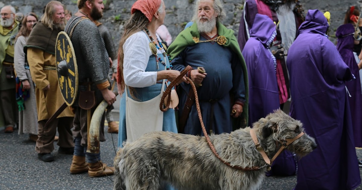 People in historical costumes with a large dog.