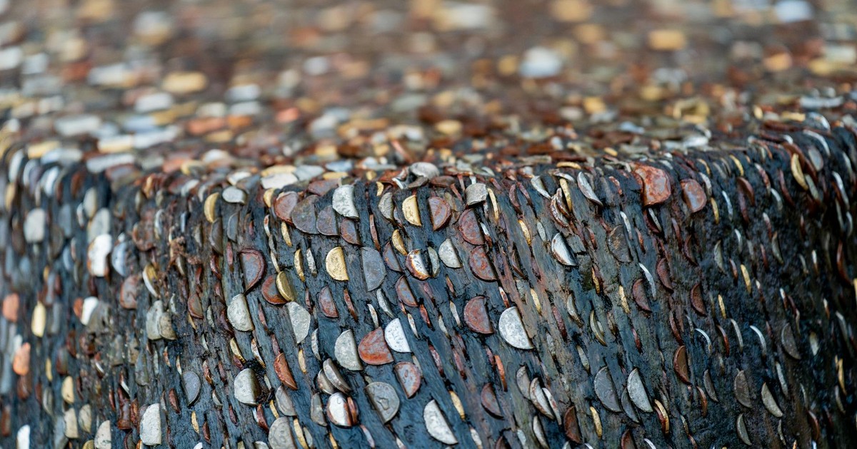 Detailed view of coins embedded in a textured concrete surface, creating a unique and artistic pattern.