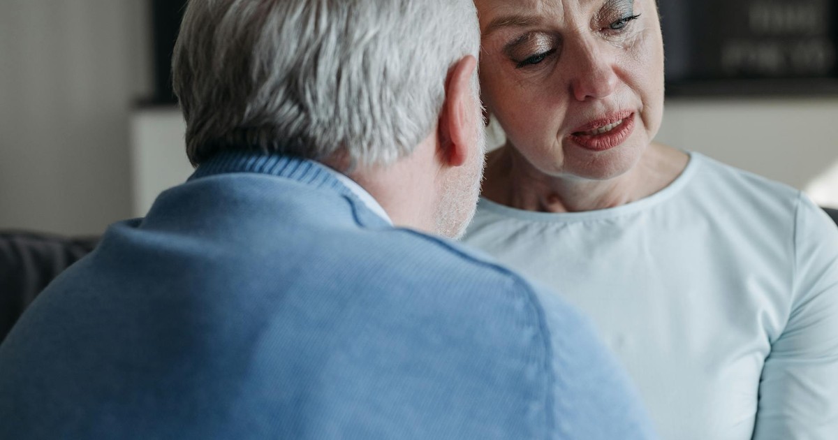 A senior couple sharing an emotional moment, showing support and empathy indoors.