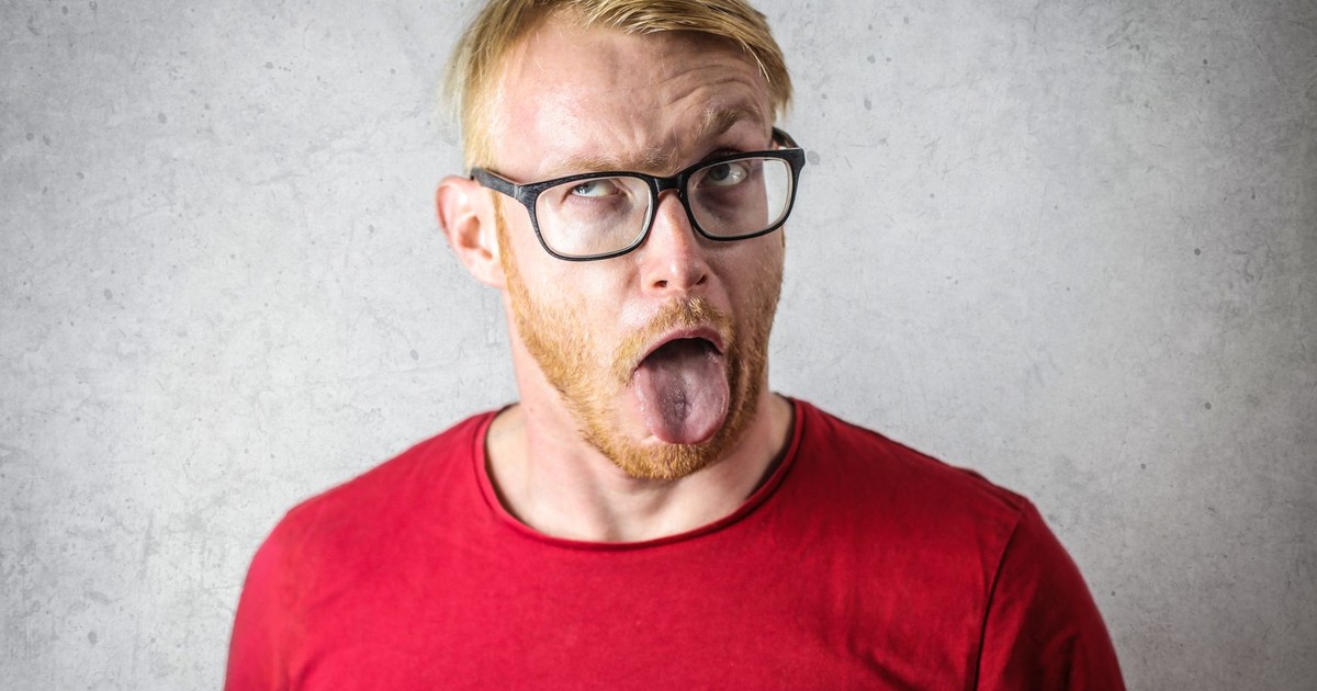 Man with glasses making a funny face, sticking out his tongue.
