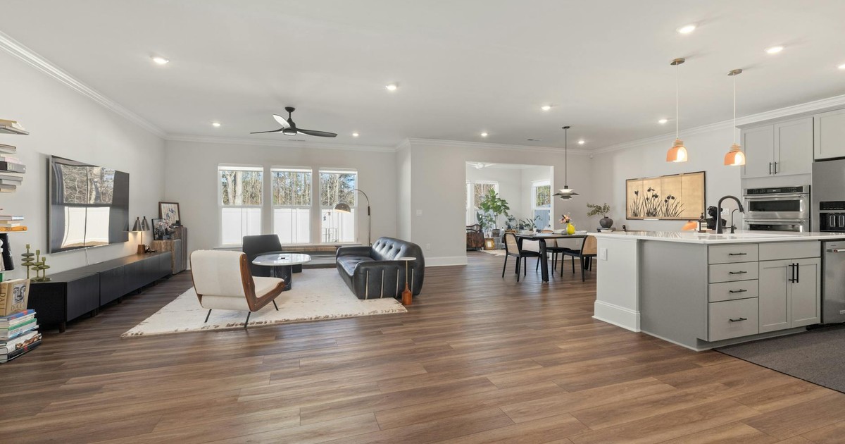 Bright and airy open-concept living space with kitchen, featuring modern furniture and elegant decor.