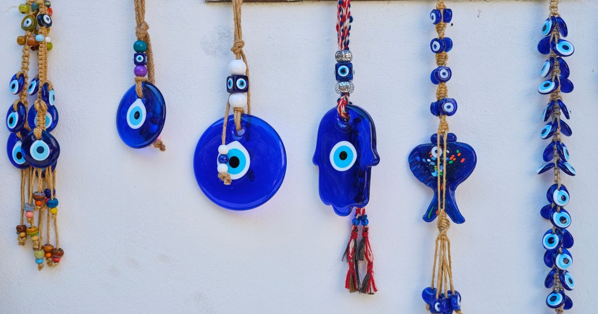 Colorful handmade evil eye wall decorations hanging on a white wall.