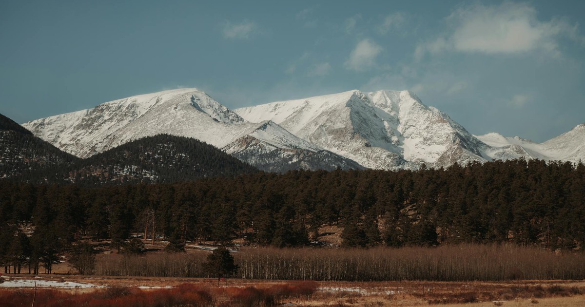 Stunning snow-covered Rocky Mountains with evergreen forest in winter landscape.