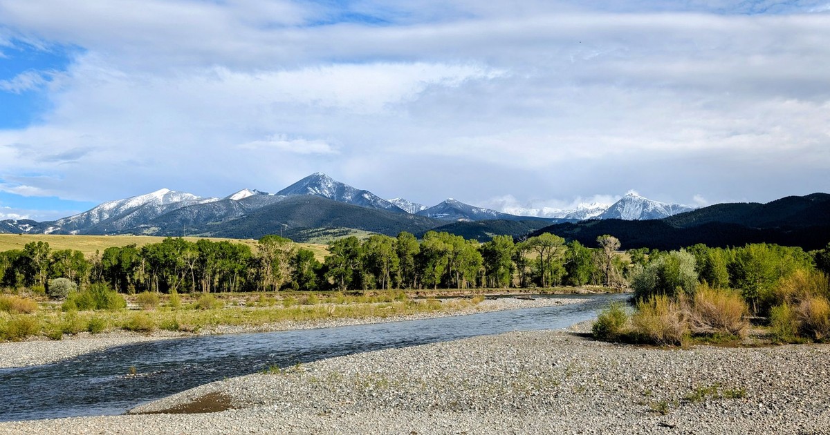 Beautiful river and mountain scene in Livingston, Montana, under a clear blue sky.