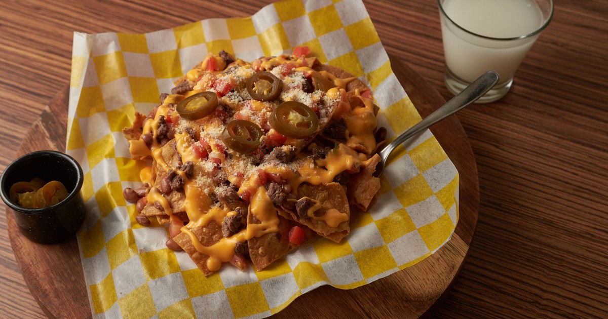 A tempting serving of cheesy nachos topped with jalapenos and melted cheese, perfect for indulgence.