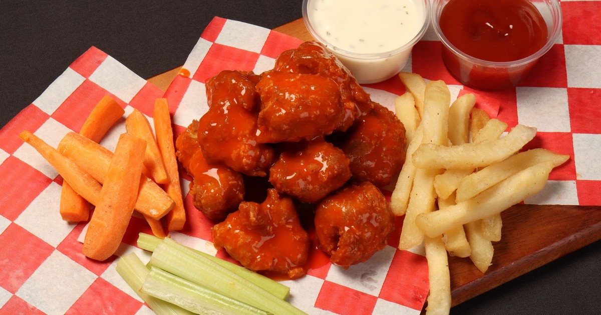 Tasty buffalo wings with vegetables and fries, perfect for a snack or party platter.