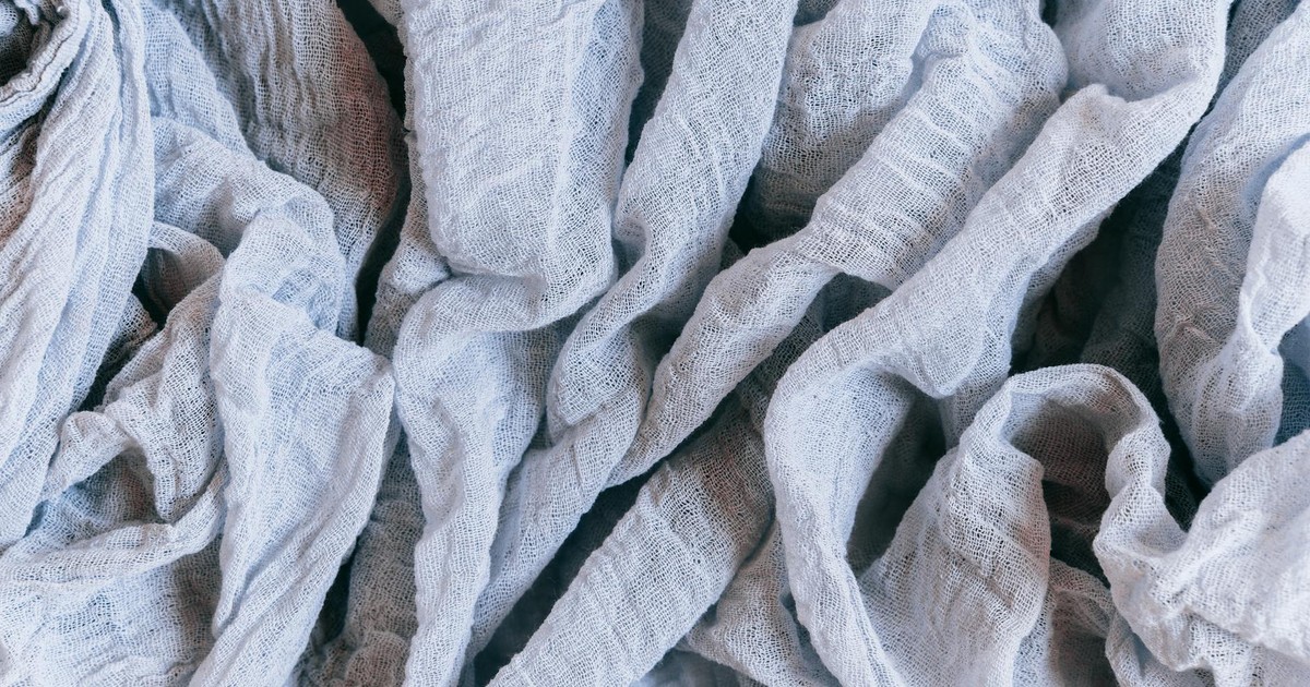 A detailed close-up of crumpled linen fabric showcasing its intricate texture and soft material.