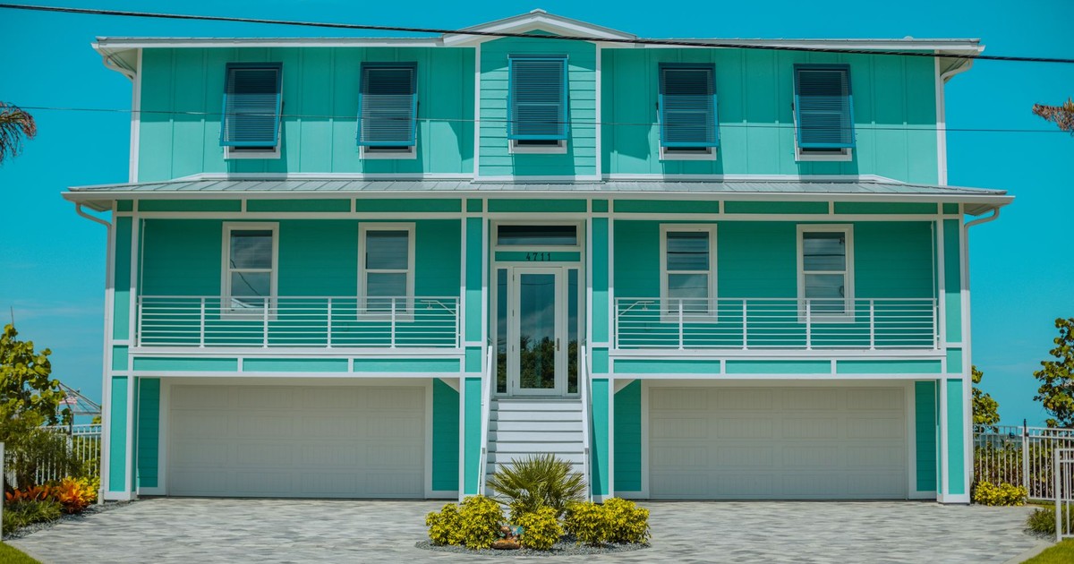 A modern teal beach house with a spacious design in Daytona Beach, Florida.