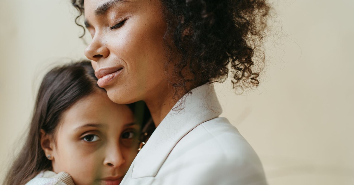 A mother and daughter share a tender embrace, expressing love and connection.
