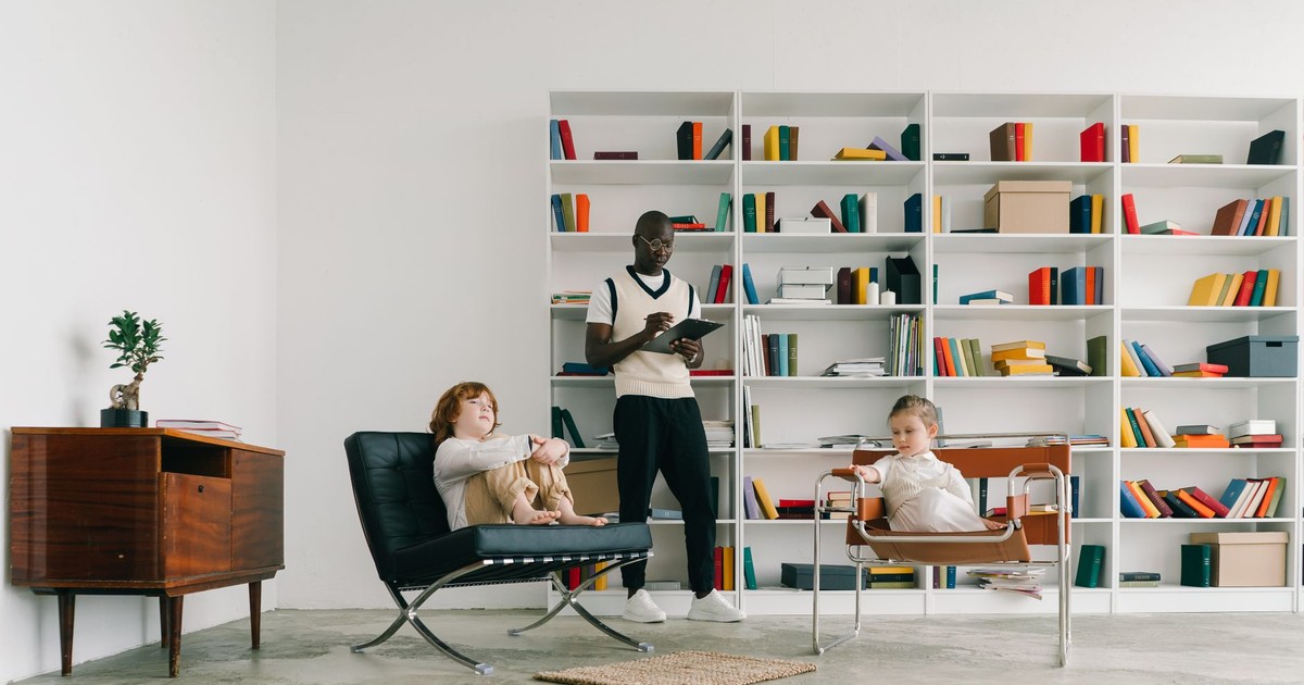 Psychologist conducts a therapy session with children in a modern library setting.