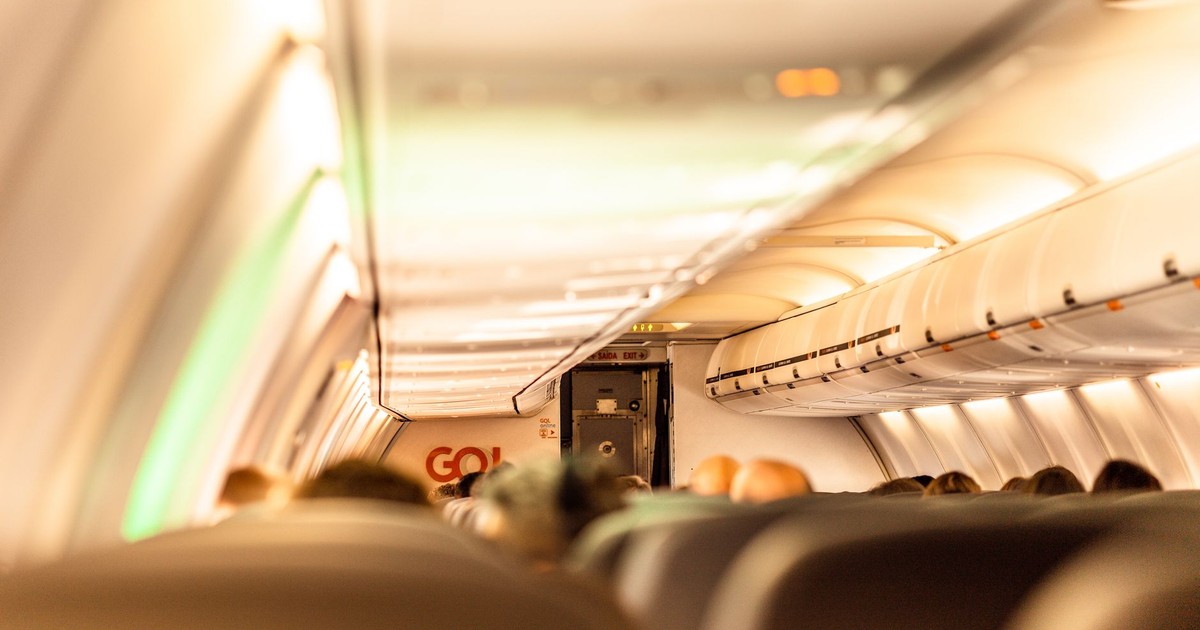Interior of a commercial airplane with passengers blurred inside the cabin, showcasing travel atmosphere.