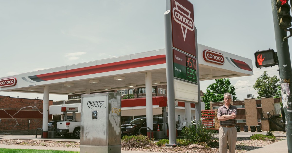 Man standing by a Conoco gas station on a sunny day in Denver, Colorado.