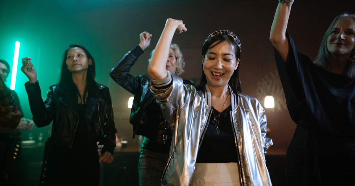 A group of women dancing and enjoying nightlife at a club, exuding joy and enthusiasm.