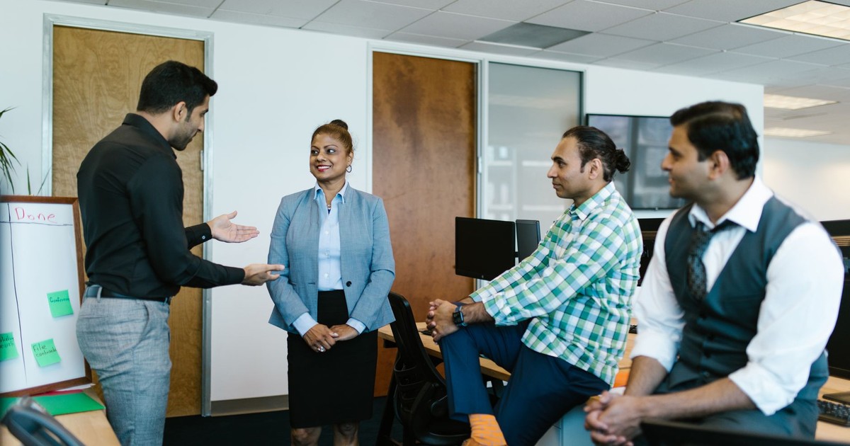 A diverse group of colleagues engaged in a collaborative meeting in a modern office setting.