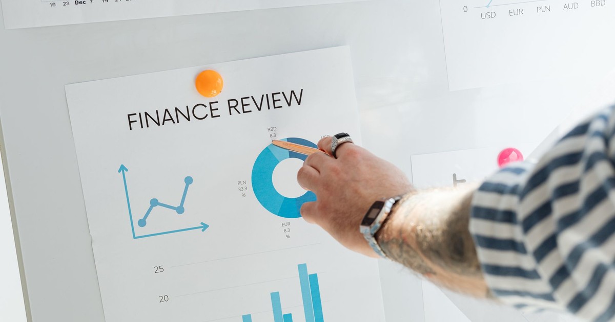 Close-up of a hand pointing to financial charts during a business review.