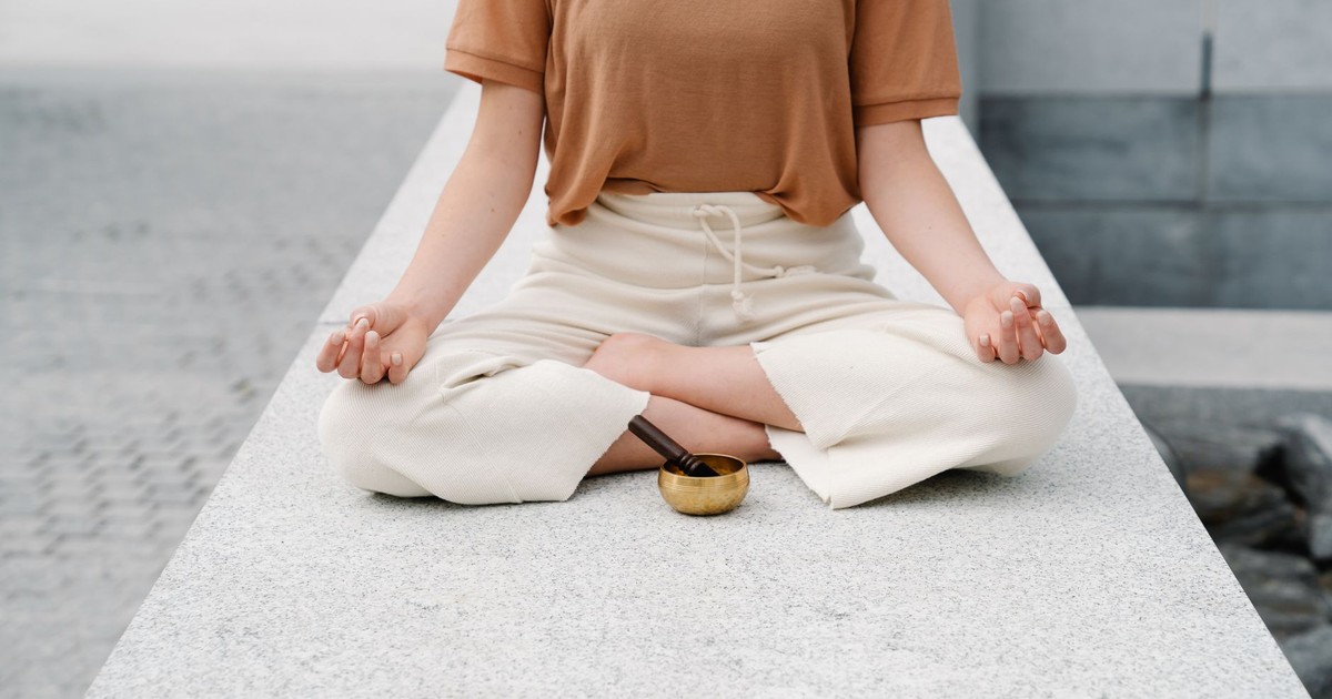 A person meditating outdoors with a singing bowl, embracing serenity and mindfulness.