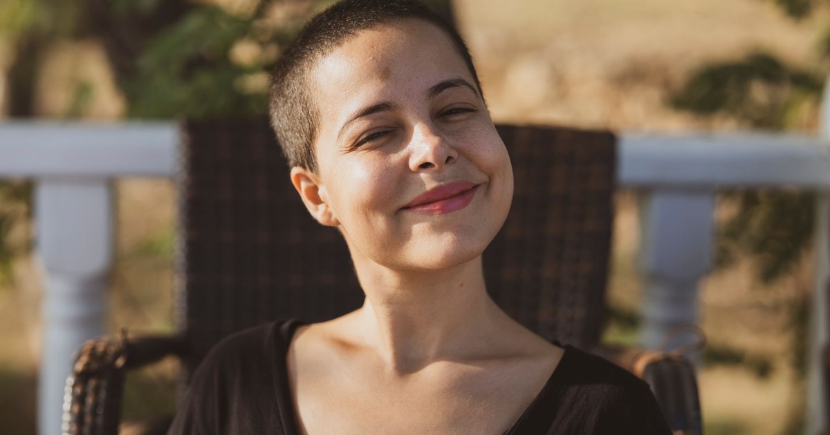 Portrait of a smiling woman enjoying a sunny day outdoors.