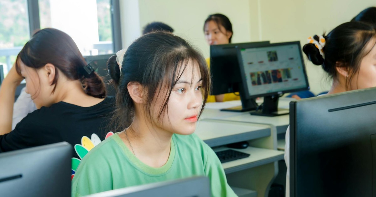 Asian students focused on studying technology in a bright computer classroom setting.