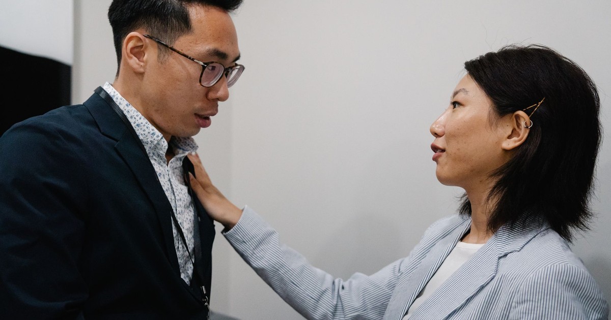 Two business professionals engage in a serious conversation indoors.