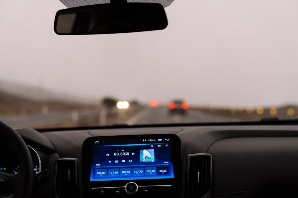 Interior view of a car dashboard on an open road during the day. Perfect for travel-themed projects