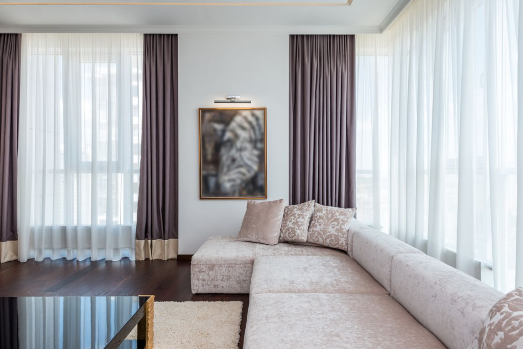 Bright and spacious modern living room featuring a sectional couch, large windows, and chic decor