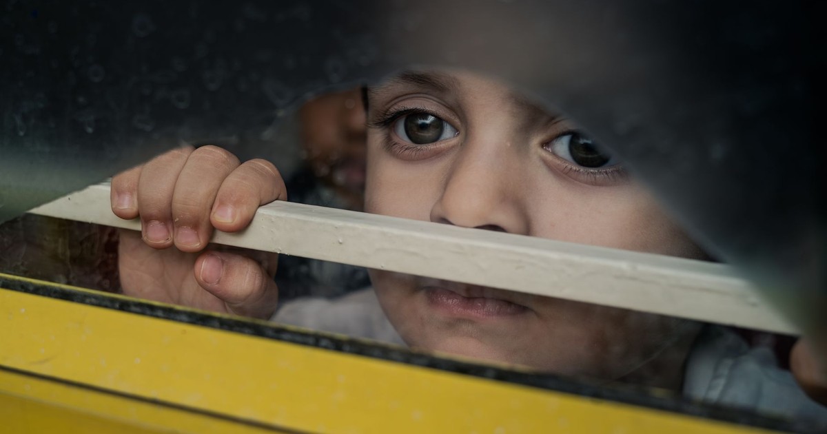 Thoughtful child peering through a window frame in Bengaluru, India.
