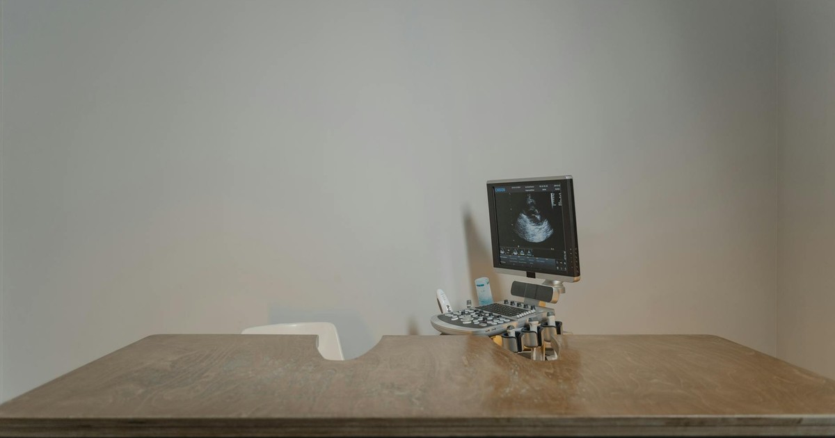 Ultrasound machine setup in a minimalist medical office for patient examinations.