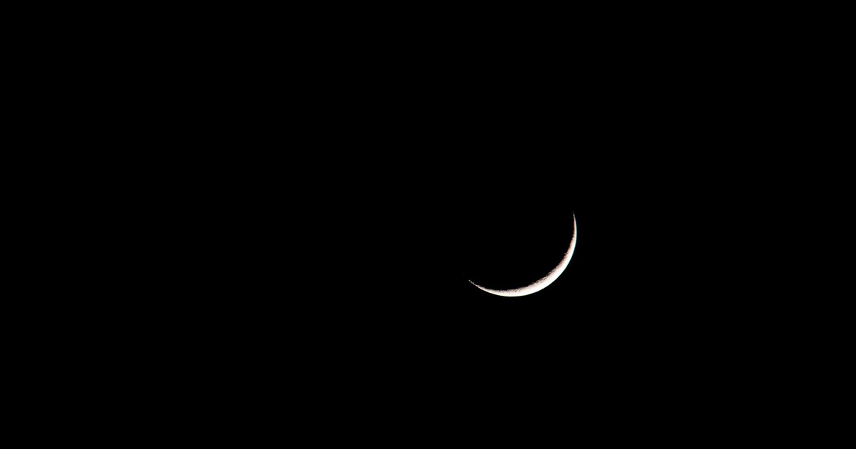 A striking image of a crescent moon set against a deep black sky, showcasing its serene beauty.