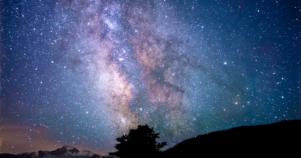 silhouette of trees and mountain under blue sky at nighttime
