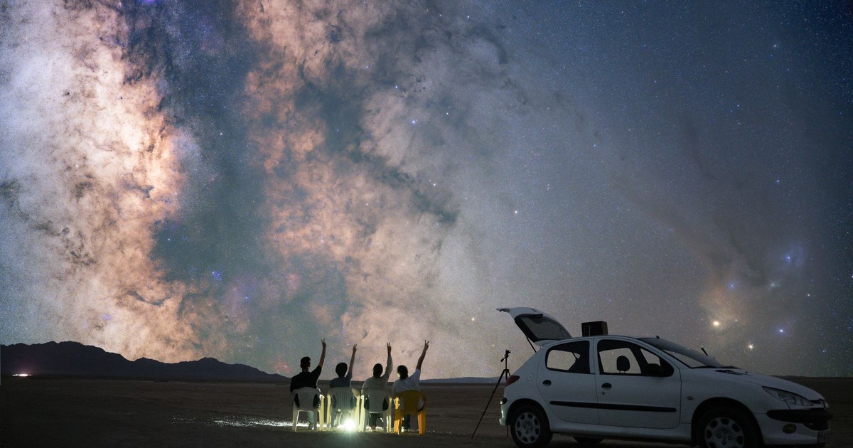 A group of stargazers observing the Milky Way in Semnan, Iran with a car and telescope.