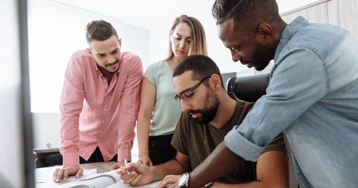 A group of diverse colleagues brainstorming and discussing a project in a modern office setting.