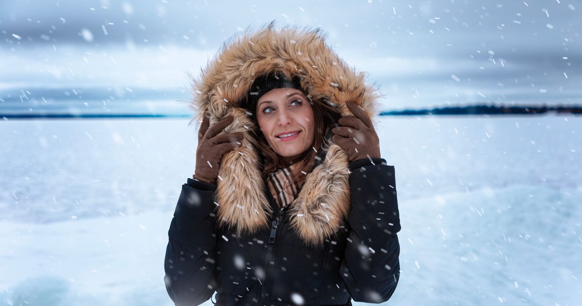 A woman in a fur-trimmed coat enjoying a snowy day outdoors in Ontario, Canada.