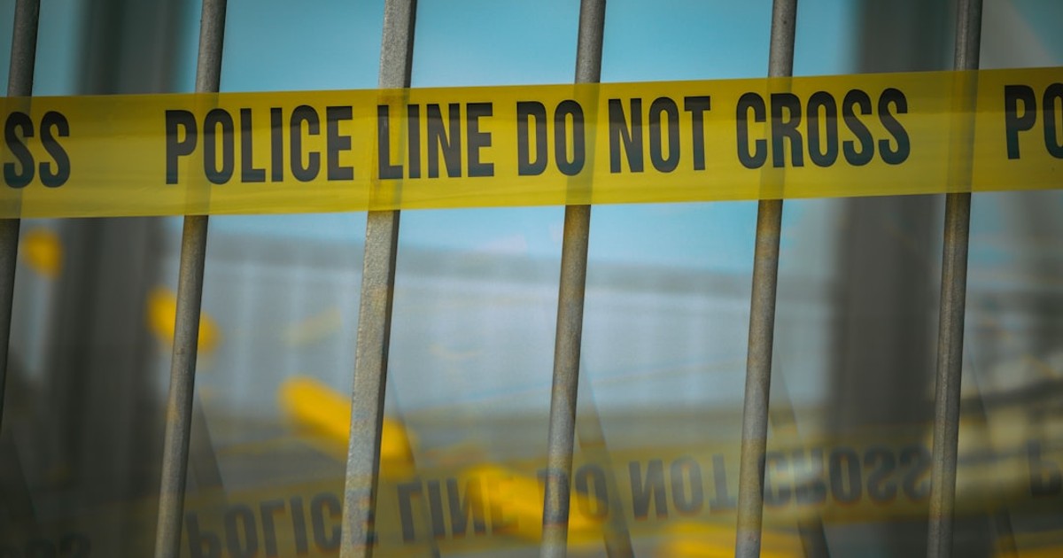 a close up of a yellow police line behind bars